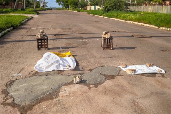 В Горловке жители с помощью подручных средств и фантазии латают ямы на дорогах 